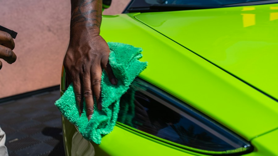 Car paint being wiped with a microfiber cloth